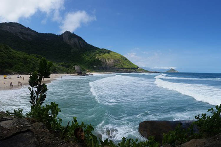 Praia cercada por vegetação e montanhas na Zona Sudoeste do Rio de Janeiro
