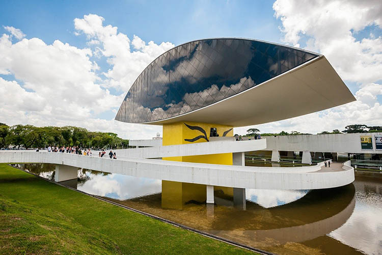 Museu Oscar Niemeyer em Curitiba com o edifício do Olho refletido no espelho d’água