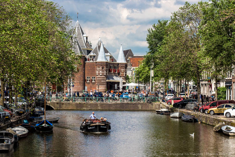 De Waag, na Nieuwmarkt, em Amsterdam, vista com barcos, bicicletas e árvores ao redor