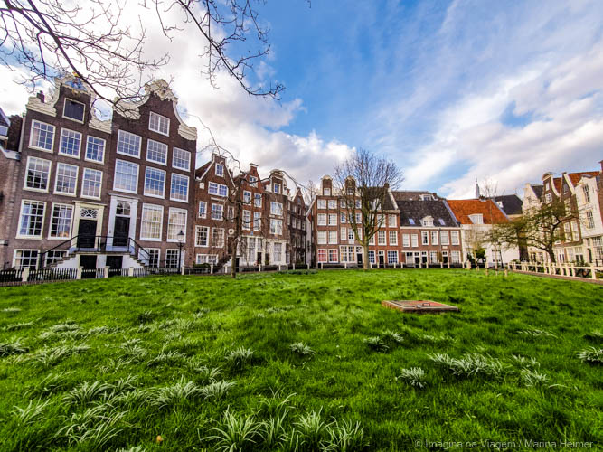 Pátio interno do Begijnhof em Amsterdam, cercado por casas históricas e área gramada