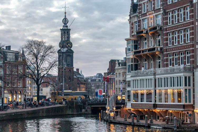 Munttoren vista da Halvemaansbrug, com casas e o rio Amstel em primeiro plano
