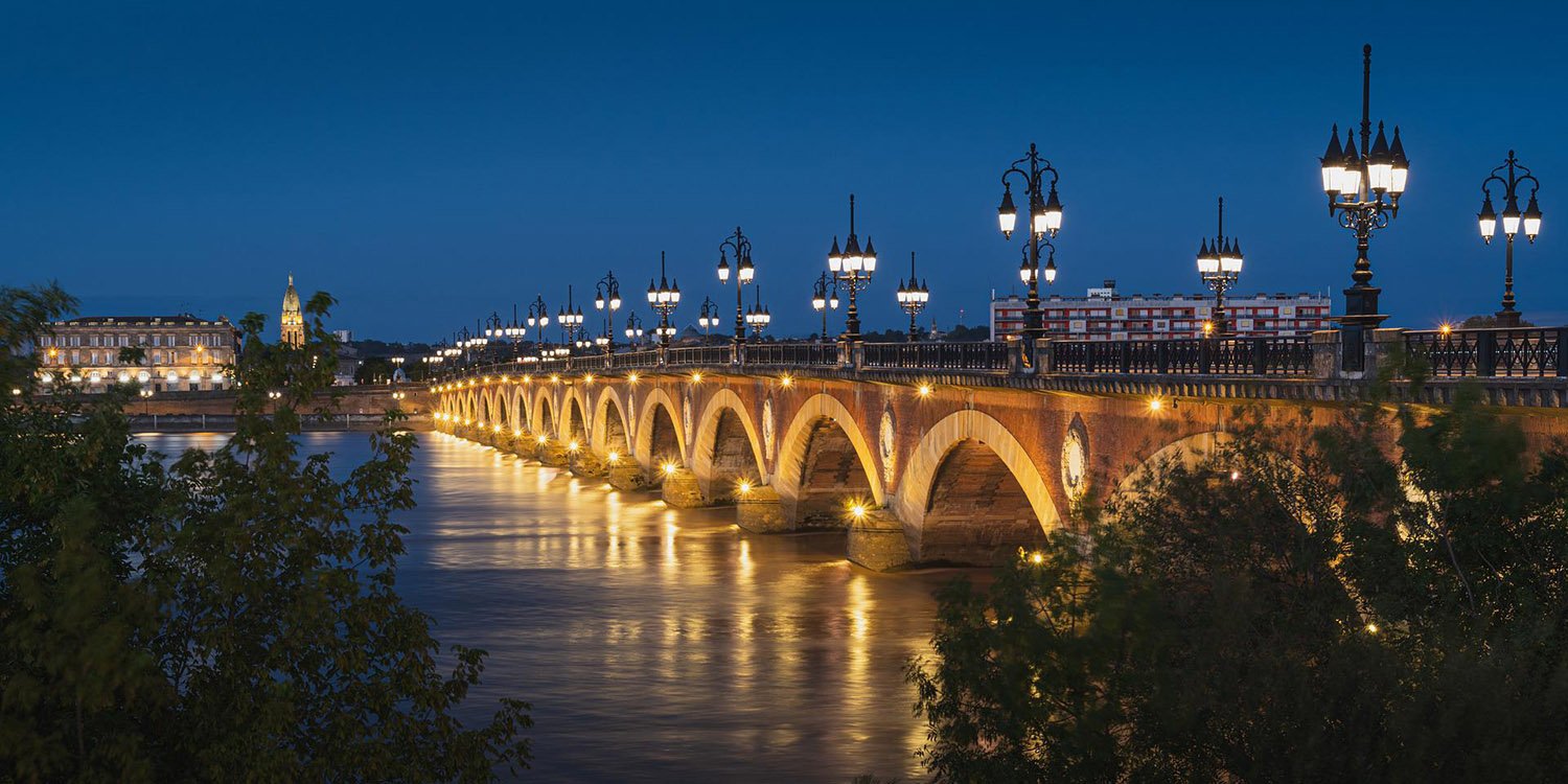 Ponte iluminada sobre o Rio Garona em Bordeaux à noite